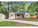 Charming home features a welcoming front porch, dark roof, detached garage, and spacious driveway at 500 Pomona Circle Sw, Atlanta, GA 30315
