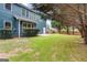 The home features a large backyard with mature trees, green grass, and an outdoor seating area at 1210 Magnolia Park Cir, Cumming, GA 30040