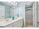Well-lit bathroom featuring double sinks, white cabinets, and a view into the toilet and tub area at 1210 Magnolia Park Cir, Cumming, GA 30040