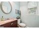 Powder bathroom featuring a granite countertop, framed mirror, toilet, and a window at 1210 Magnolia Park Cir, Cumming, GA 30040
