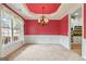 Elegant dining room showcasing modern chandelier, wainscoting and red accent wall at 1210 Magnolia Park Cir, Cumming, GA 30040