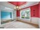 Elegant dining room featuring decorative chandelier, wainscoting and red accent wall at 1210 Magnolia Park Cir, Cumming, GA 30040