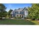 Two-story home boasts manicured lawn, stylish blue siding, dark shutters, and stone accents at 1210 Magnolia Park Cir, Cumming, GA 30040