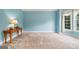 Sunlit living room features a bay window, neutral carpet, blue walls and stylish desk at 1210 Magnolia Park Cir, Cumming, GA 30040