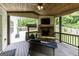 Cozy outdoor living space with a stone fireplace, comfortable seating, and a wooded view at 101 High Bluff Trl, Carrollton, GA 30116