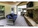 Relaxing covered deck features stone fireplace, wicker seating, and tranquil wooded views at 101 High Bluff Trl, Carrollton, GA 30116