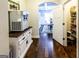 Hallway with hardwood floors leading to dining area and pantry with lots of shelf space at 101 High Bluff Trl, Carrollton, GA 30116