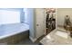 Main bathroom featuring soaking tub, large window and walk-in closet at 101 High Bluff Trl, Carrollton, GA 30116