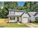 Well-maintained two-story home with a white exterior, black accents, and a neatly landscaped front yard at 131 Turning Pt, Stockbridge, GA 30281