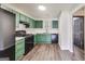 Well-lit kitchen with green cabinets, black appliances, and modern finishes, creating a stylish cooking space at 131 Turning Pt, Stockbridge, GA 30281