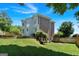 Spacious backyard with mature trees, lawn, and a retaining wall leading to the home at 3400 Dencrest Se Ct, Smyrna, GA 30080