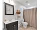 Simple bathroom with black vanity, neutral colored shower curtain and toilet at 3400 Dencrest Se Ct, Smyrna, GA 30080