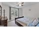 A light-filled bedroom featuring a dark wood bed frame and dresser with a window that offers a leafy view at 3400 Dencrest Se Ct, Smyrna, GA 30080