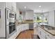 Elegant kitchen featuring white cabinetry, stainless steel appliances, and an island with a cooktop at 3400 Dencrest Se Ct, Smyrna, GA 30080