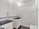 A well-organized mudroom features white cabinets, black countertops and stylish hooks for coats and bags at 3400 Dencrest Se Ct, Smyrna, GA 30080