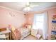 Cozy pink bedroom featuring a ceiling fan, natural light, and a charming floral-themed decor at 150 Sandy Ridge Trl, Fayetteville, GA 30214