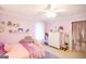 Pastel bedroom with pink accents features a ceiling fan, window, and closet at 150 Sandy Ridge Trl, Fayetteville, GA 30214