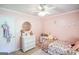 Charming bedroom showcasing a round mirror, a bright window, and delicate floral accents at 150 Sandy Ridge Trl, Fayetteville, GA 30214