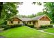 Charming brick home with cedar shake accents, shutters and a lush green lawn and stone walkway at 150 Sandy Ridge Trl, Fayetteville, GA 30214