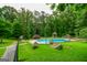 In-ground pool surrounded by mature trees, a gazebo, and landscaped grounds, offering a serene escape at 150 Sandy Ridge Trl, Fayetteville, GA 30214