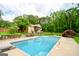 Beautiful backyard pool with diving board, surrounded by the home, trees, and lush green lawn at 150 Sandy Ridge Trl, Fayetteville, GA 30214