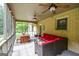 Beautiful screened porch with brick accents, ceiling fans, wicker furniture, and outdoor dining space at 150 Sandy Ridge Trl, Fayetteville, GA 30214