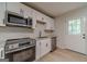 Updated kitchen with stainless appliances, white cabinetry, granite countertops, and hardwood flooring at 3404 Broxton Mill Way, Snellville, GA 30039