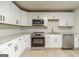 Well-lit kitchen features white cabinets, stainless steel appliances, and granite countertops at 3404 Broxton Mill Way, Snellville, GA 30039