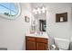 Bathroom featuring a vanity with round window, a mirror, toilet, and decorative touches, creating a functional and charming space at 1858 Preserve Way, Atlanta, GA 30341