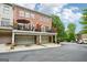 Three-story townhome showcasing a brick exterior, garages, and upper level deck at 1858 Preserve Way, Atlanta, GA 30341