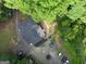 Aerial view of house showing the surrounding landscape with gravel driveway and many tall, green trees at 6290 Cascade Palmetto Hwy, Fairburn, GA 30213