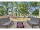 Outdoor patio with seating area surrounded by mature trees, fenced yard, and storage buildings at 6290 Cascade Palmetto Hwy, Fairburn, GA 30213