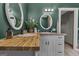 Bathroom vanity featuring double sinks, stylish mirrors, wood counters, and classic white cabinets at 6290 Cascade Palmetto Hwy, Fairburn, GA 30213
