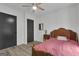 This bedroom has a ceiling fan, hardwood floors, a classic wooden headboard, and contrasting black doors at 6290 Cascade Palmetto Hwy, Fairburn, GA 30213