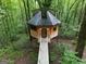 Unique treehouse home with a wooden walkway nestled in a serene, wooded environment at 6290 Cascade Palmetto Hwy, Fairburn, GA 30213