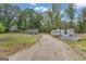 Exterior shot of RV, solar panels, and tractor with a large open field surrounded by green trees at 6290 Cascade Palmetto Hwy, Fairburn, GA 30213