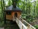 Unique treehouse home with a wooden walkway nestled in a serene, wooded environment at 6290 Cascade Palmetto Hwy, Fairburn, GA 30213