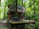 Stunning treehouse exterior featuring a wrap-around deck, seating, hot tub, and metal cable railings at 6290 Cascade Palmetto Hwy, Fairburn, GA 30213