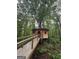 Unique treehouse home with a wooden walkway nestled in a serene, wooded environment at 6290 Cascade Palmetto Hwy, Fairburn, GA 30213