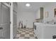 Functional laundry room with washer, dryer, storage cabinets, and checkered flooring at 6290 Cascade Palmetto Hwy, Fairburn, GA 30213