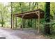 Outdoor shed structure featuring a slanted roof with timber beams and gravel ground with a forested background at 6290 Cascade Palmetto Hwy, Fairburn, GA 30213
