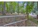 View of front yard with a small white storage shed and a white house with a black roof in the distance at 6290 Cascade Palmetto Hwy, Fairburn, GA 30213