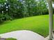View of the backyard featuring a large green lawn and perimeter of lush, mature trees at 920 Courthouse Rd, Temple, GA 30179