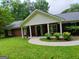 Charming brick home featuring a covered entryway, manicured lawn, and mature trees at 920 Courthouse Rd, Temple, GA 30179