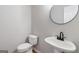 A clean half bath featuring a pedestal sink and modern round mirror at 2268 Nicole Dr, Hampton, GA 30228