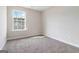 A well-lit bedroom with neutral walls, a carpeted floor, and a window offering natural light at 2268 Nicole Dr, Hampton, GA 30228