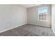 The carpeted bedroom has neutral colored walls, a window for natural light, and electrical outlets at 2268 Nicole Dr, Hampton, GA 30228