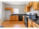 Bright kitchen features wood cabinets, laminate floors, black countertops and black appliances at 2268 Nicole Dr, Hampton, GA 30228