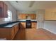 Well-lit kitchen featuring wooden cabinets, black countertops, and black appliances at 2268 Nicole Dr, Hampton, GA 30228