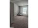Well-lit bedroom featuring a neutral color scheme and plush carpeting at 1049 Homer Ln, Stockbridge, GA 30281